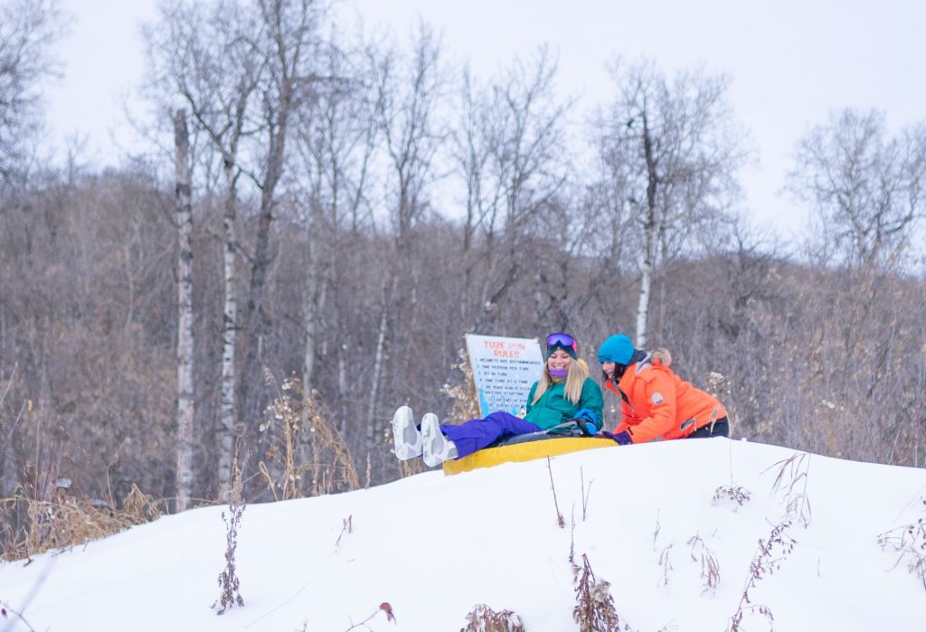 Woman getting pushed down hill at Duck Mountain Ski Area