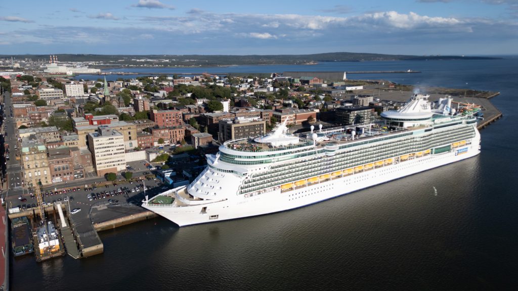 A large passenger cruise ship docked in front of Saint John, New Brunswick.